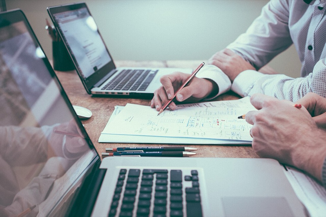 Personnes travaillant ensemble sur ordinateurs portables.